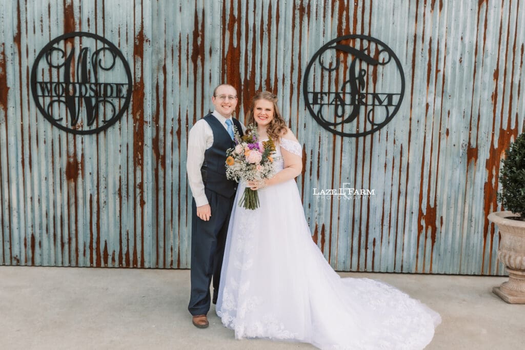 Bride and Groom standing in front of their wedding venue at Woodside Farm in Graham, NC pictures by Laze L Farm Photography