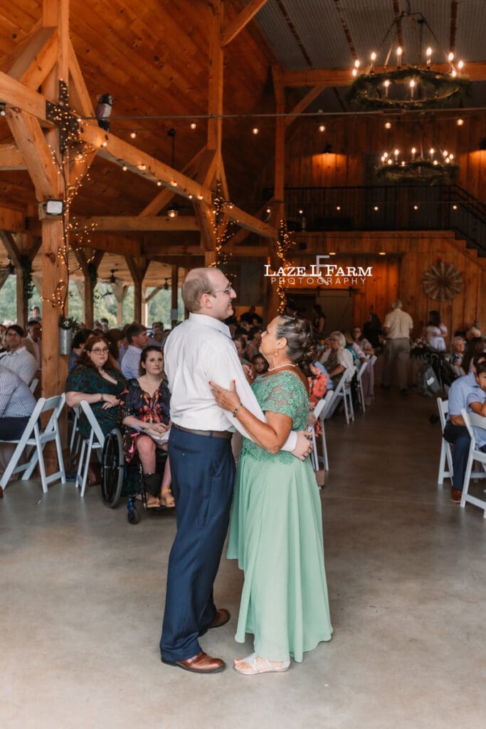 Groom and mother of the groom during their first dance at Woodside Farm in Graham, NC with pictures by Laze L Farm Photography