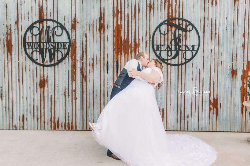 Bride and Groom getting dipped in front of their wedding venue at Woodside Farm in Graham, NC with pictures by Laze L Farm Photography