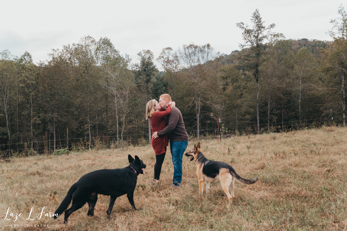 Laze L Farm Photography | Farm Pregnancy Announcement | Taylorsville NC | Husband and Wife in Field with Dogs
