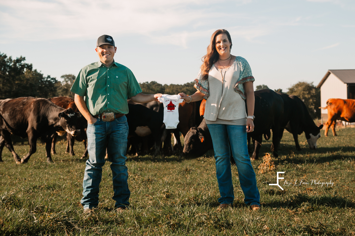 Laze L Farm Photography | Farm Session | Taylorsville NC | Couple holding the onesie