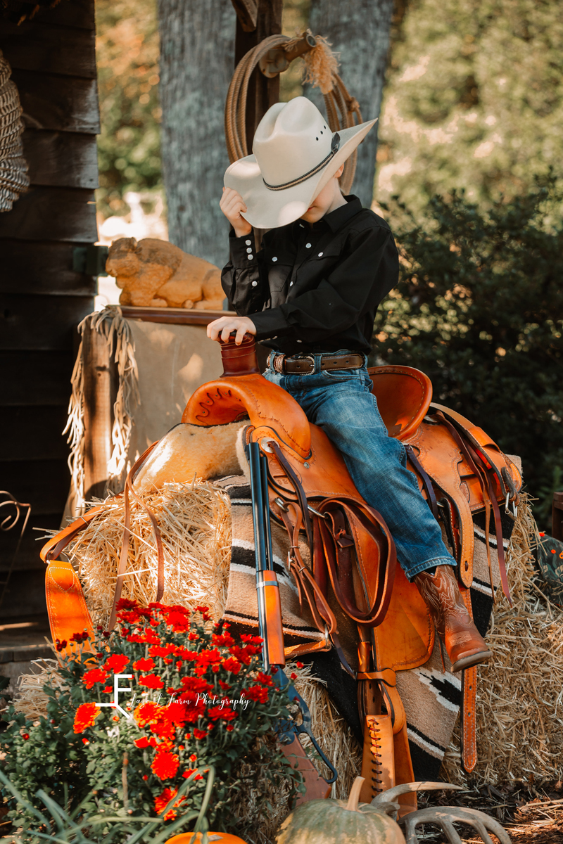 Laze L Farm Photography | Farm Session | Taylorsville NC | tipping his hat on the saddle 