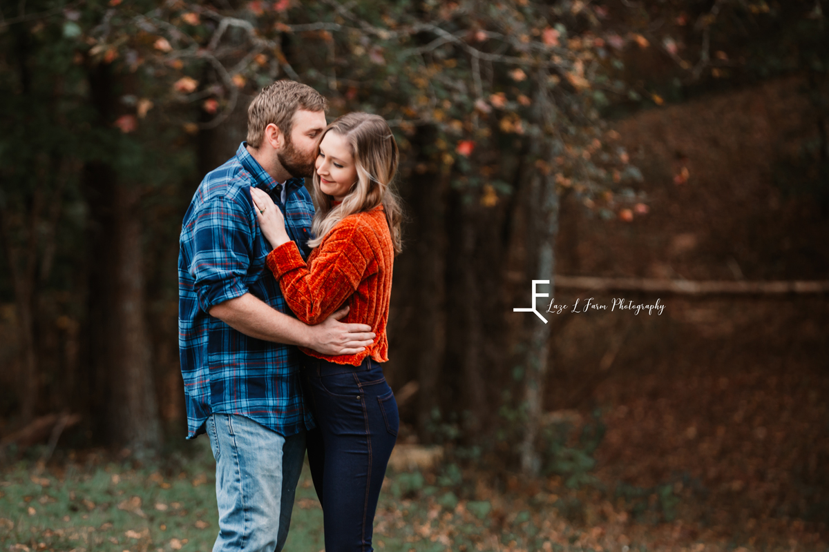 Laze L Farm Photography | Farm Session | Taylorsville NC | younger couple holding onto each other, face kisses