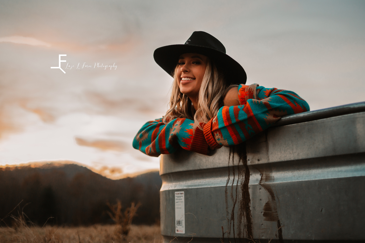 Laze L Farm Photography | Beth dutton | Water Trough | Taylorsville NC | smiling wearing the jacket in the field