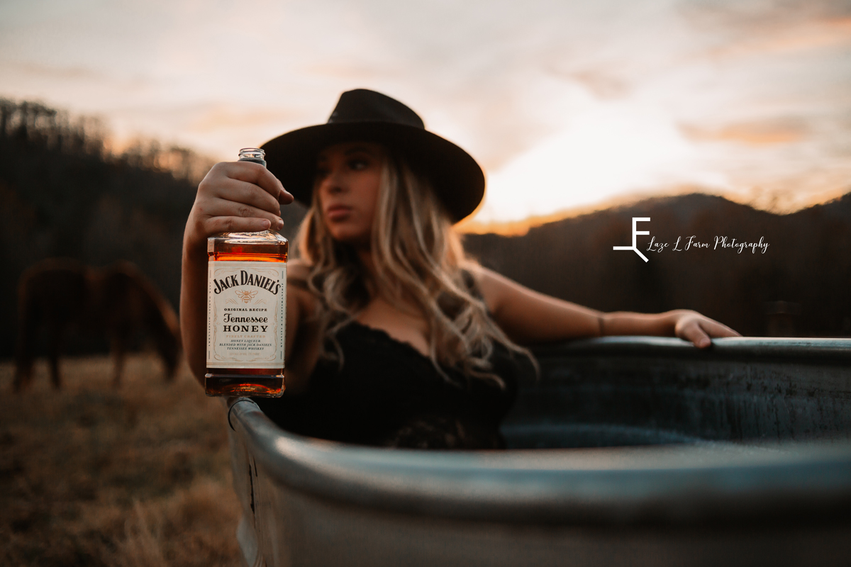 Laze L Farm Photography | Beth dutton | Water Trough | Taylorsville NC | focused on the bottle of whiskey