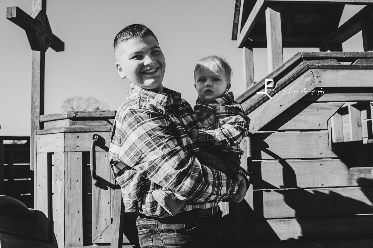Laze L Farm Photography | Farm Session | Taylorsville NC | black and white of brother holding baby brother