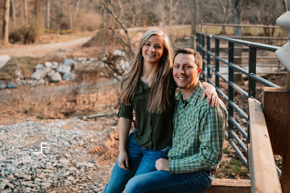 Laze L Farm Photography | Engagement Session | Taylorsville NC | posed on his lap on fence