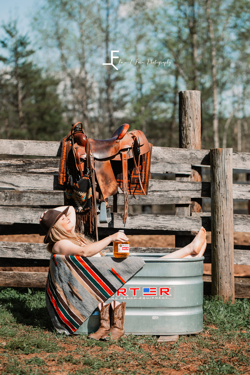 Laze L Farm Photography | Beth Dutton Water Trough | posing in the trough with the whisky bottle