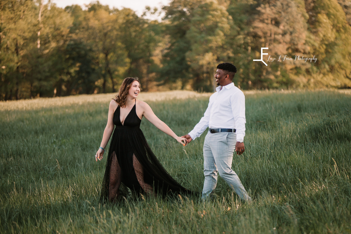 Laze L Farm Photography | Engagement Session | The Emerald Hill - Hiddenite NC | holding hands and walking through the field