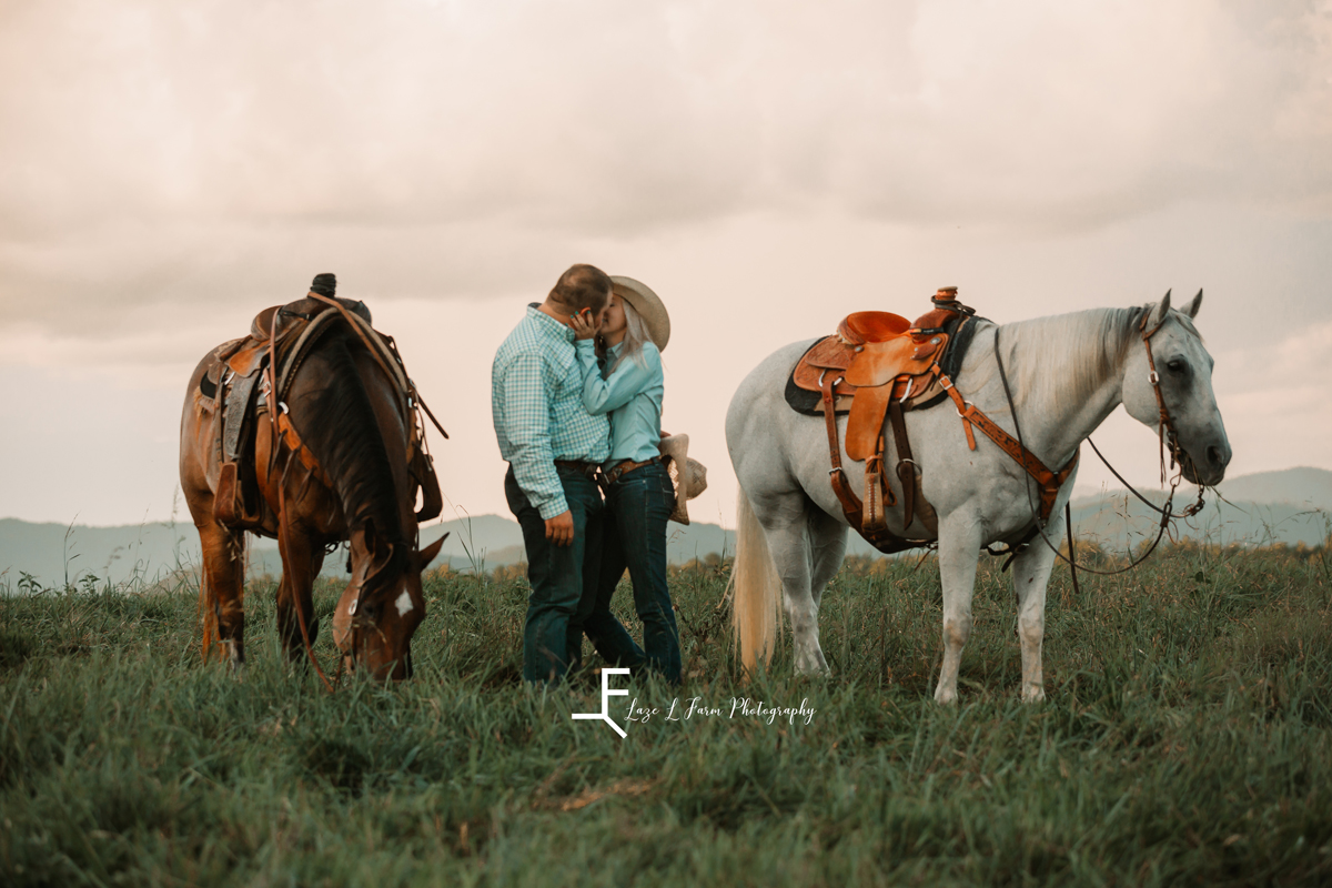 Laze L Farm Photography | Cowboy Couple | Taylorsville NC | couple kissing with horses in the background