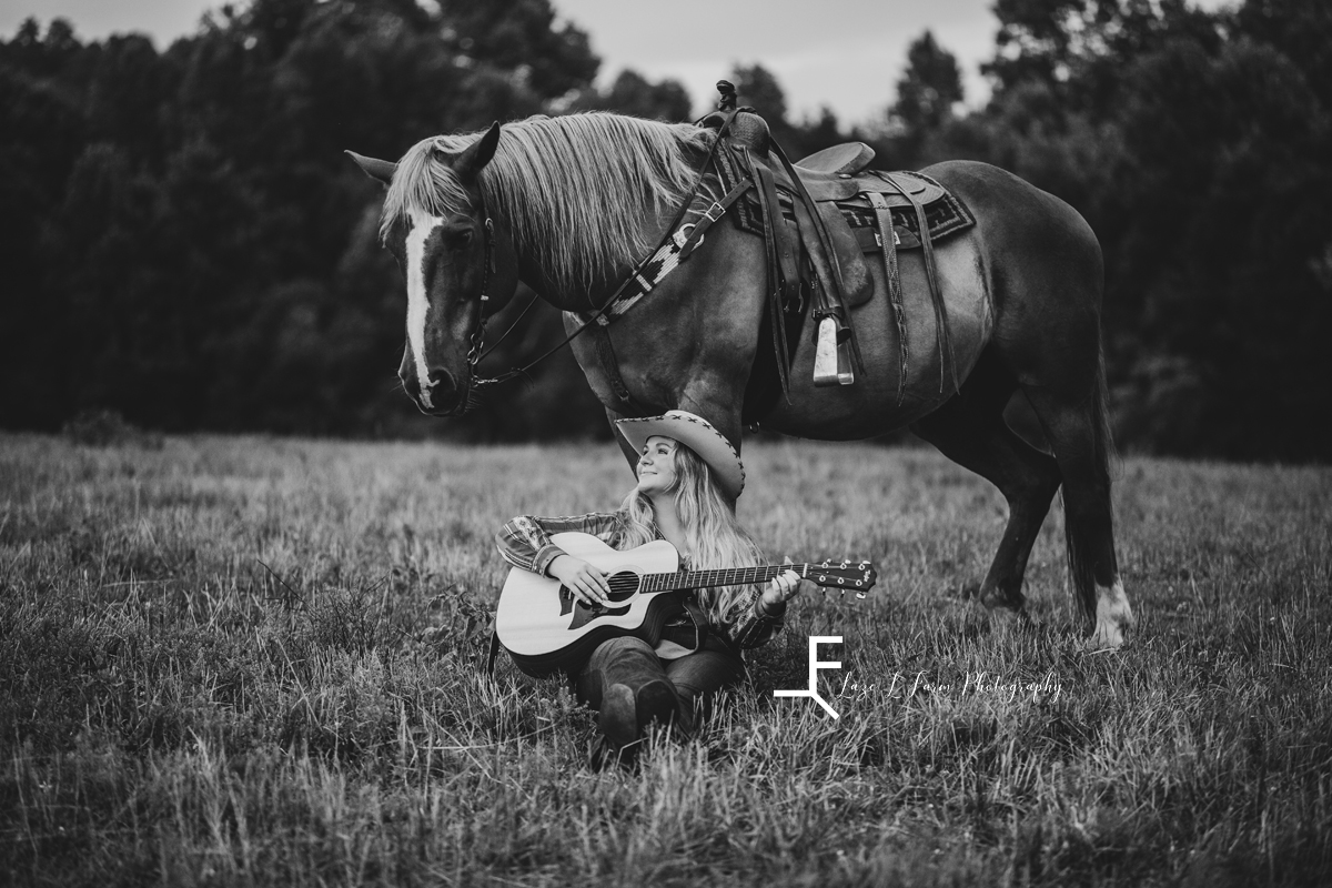 black and white girl leaning on horse playing guitar 