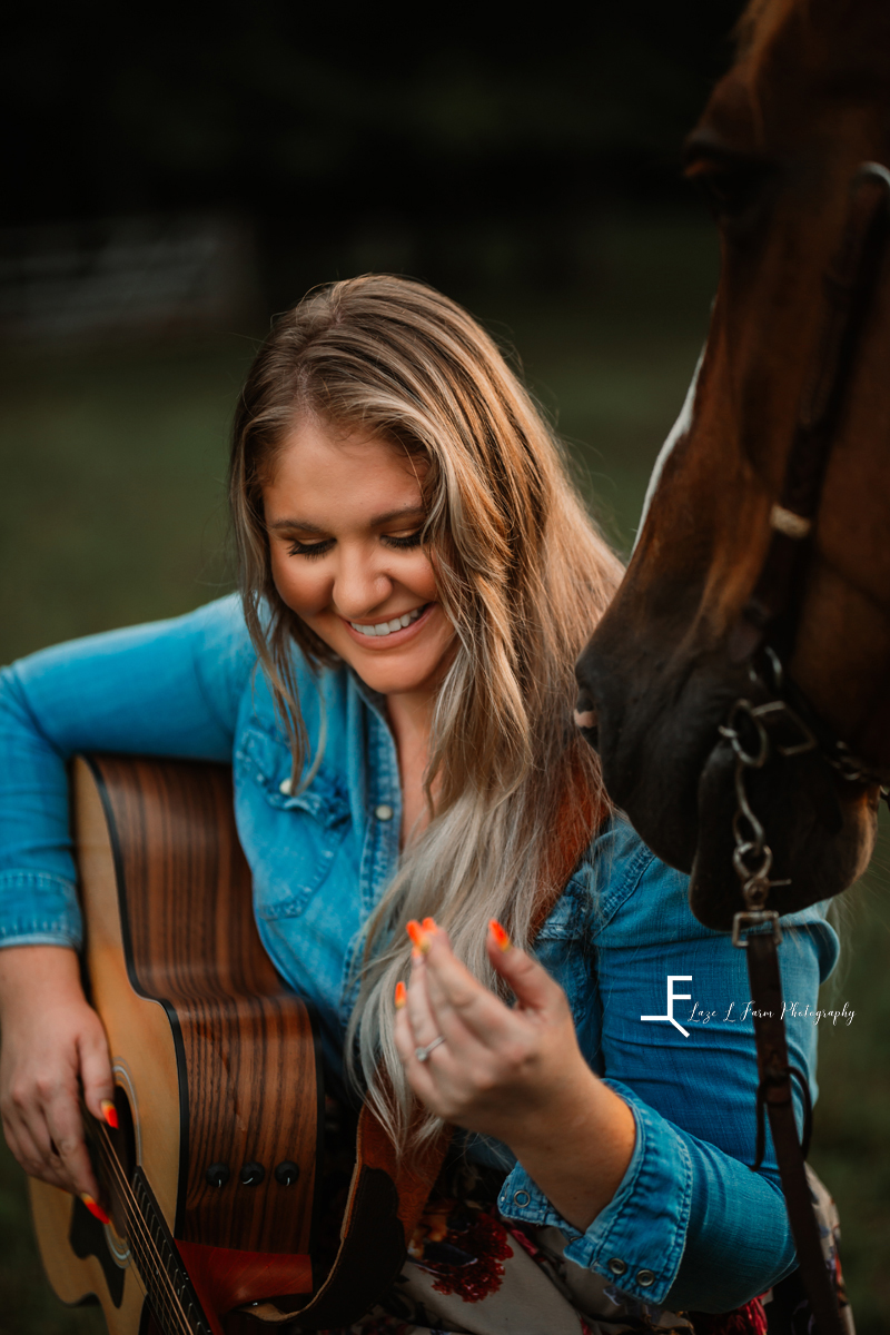 girl laughing with guitar and horse