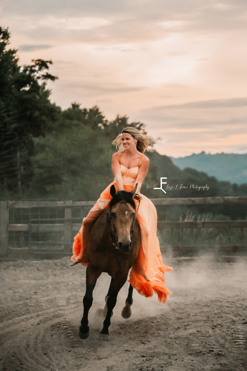 Girl in orange dress cantering horse