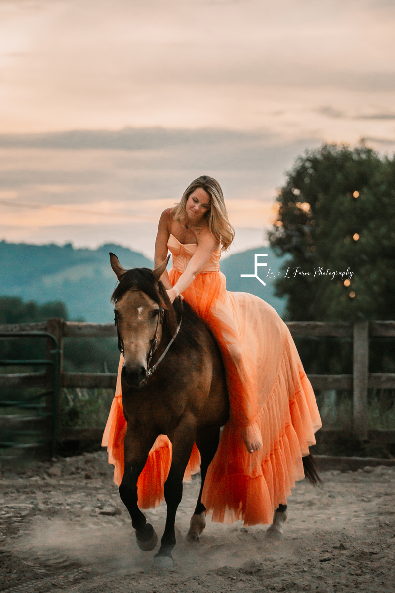 girl in orange dress petting horse