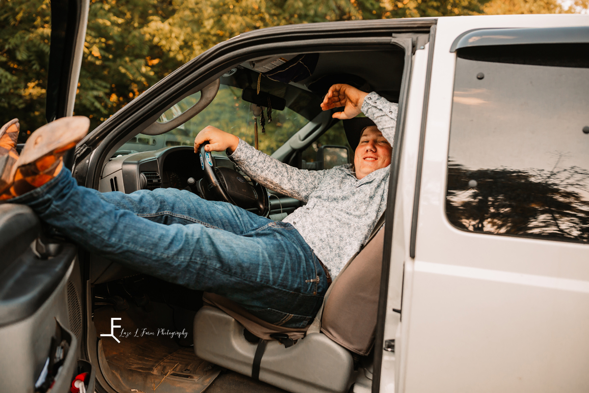 guy leaned back with feet on door of truck