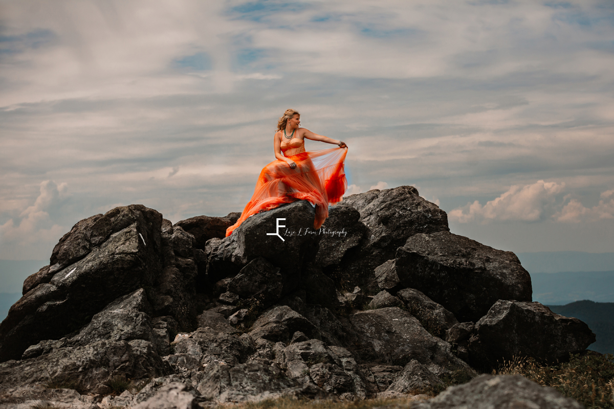 girl in orange dress on rocks 