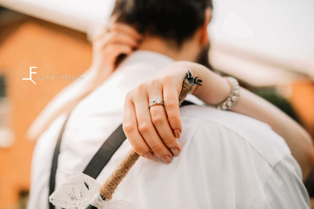 engagement ring over grooms shoulder