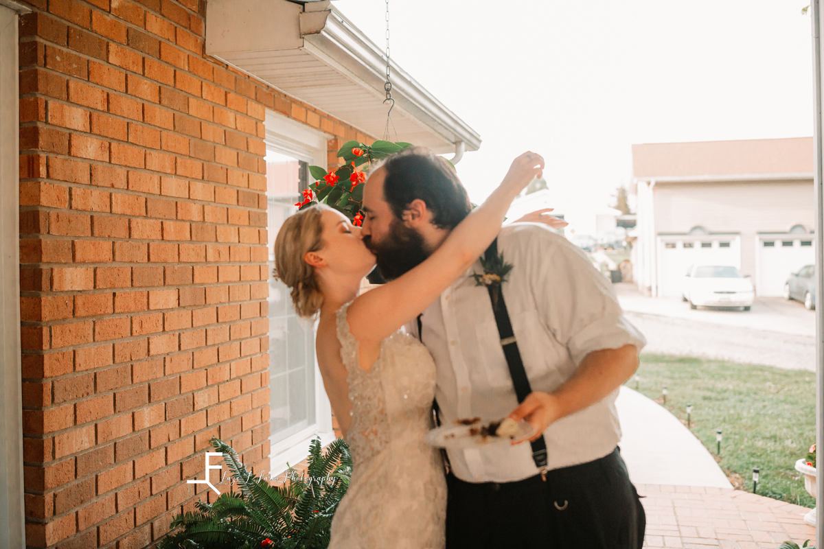 bride and groom kissing after cake cutting