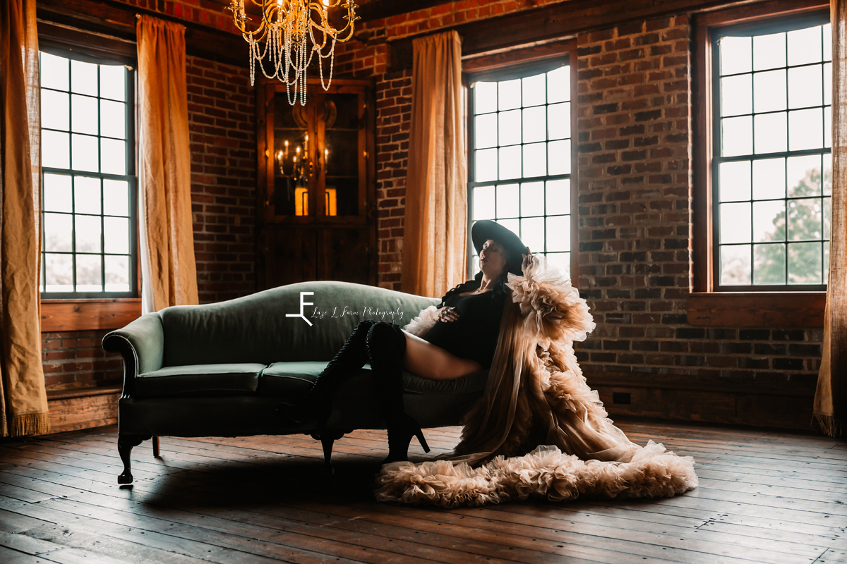 pregnant woman in fringed robe on vintage couch