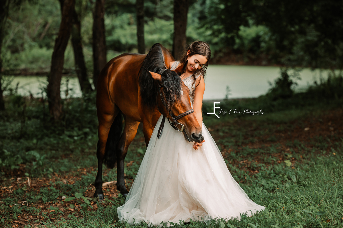 girl in white dress hugging horse