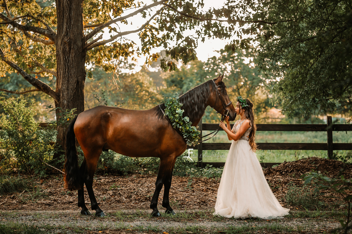 girl in white dress kissing the nose of the horse