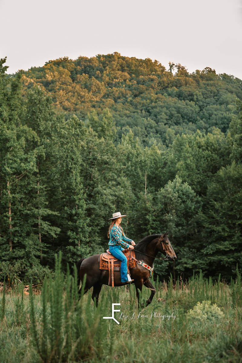 girl riding black horse in front of mountain