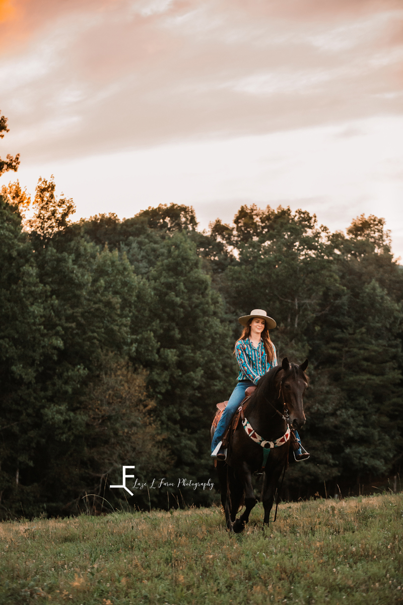 girl riding black horse facing forward 