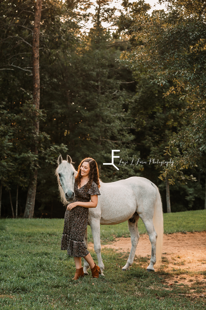 gray horse with girl in sundress in field