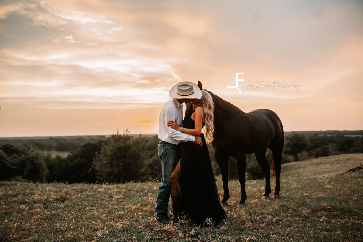 cowboy kissing wife with horse in background