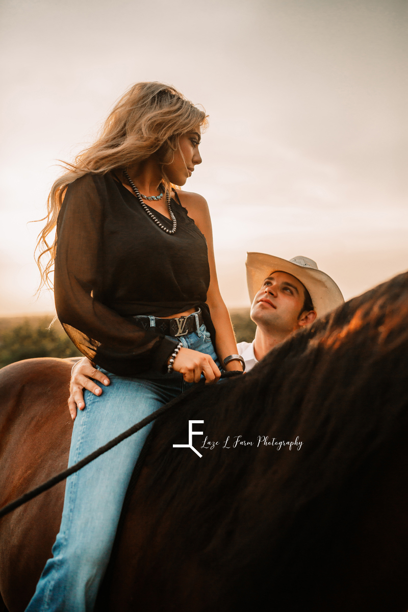wife sitting on horse and cowboy looking at her
