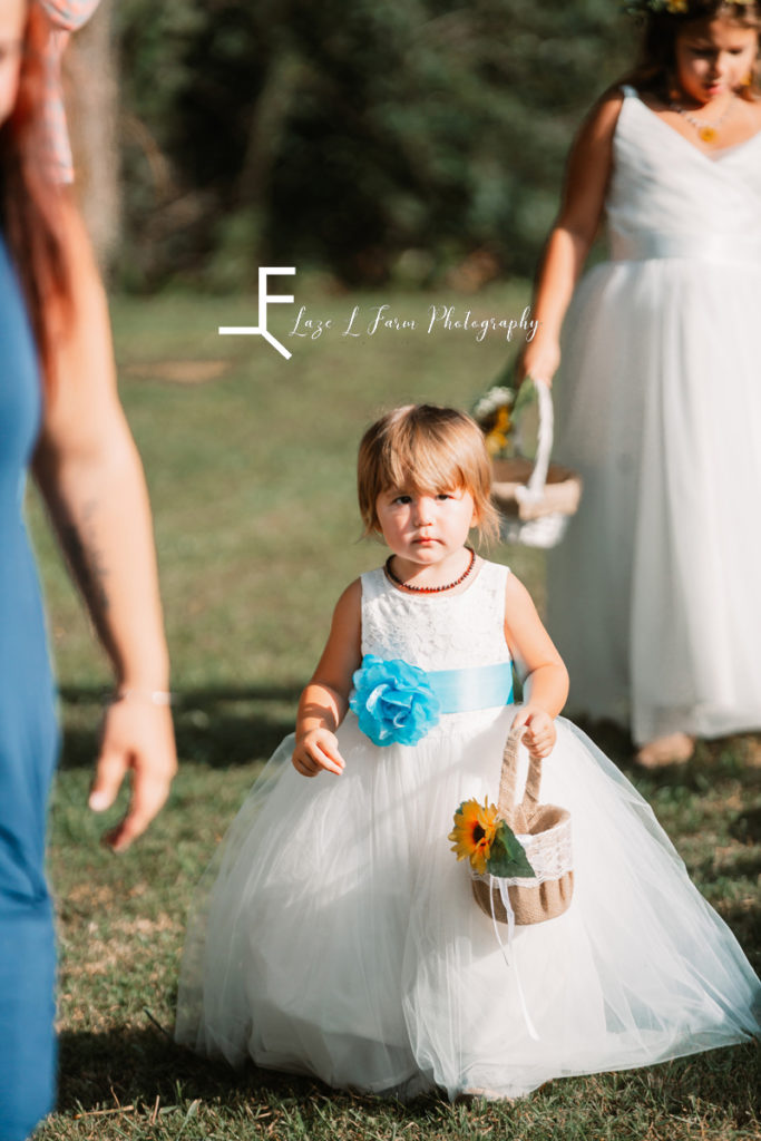 flower girl in white dress with teal flower