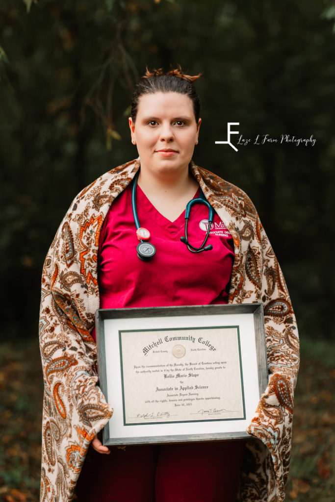 nurse wrapped in blanket with diploma