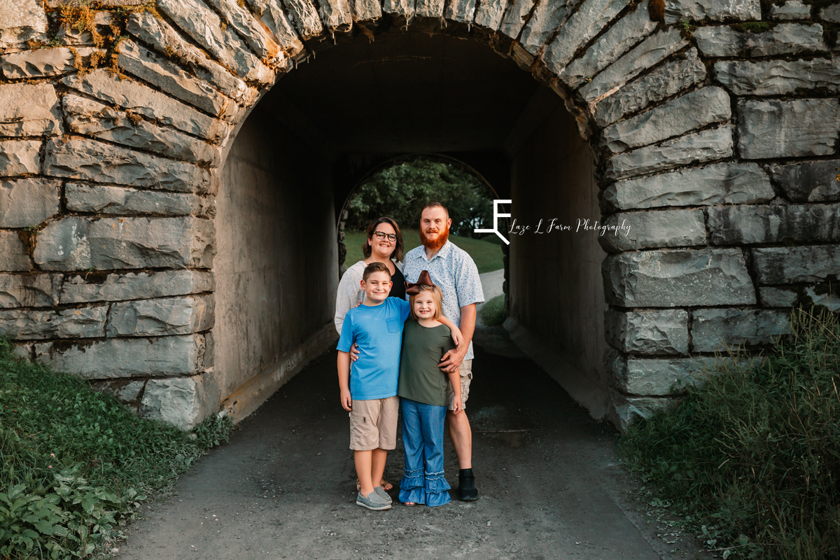 mom, dad and 2 kids in front of bridge