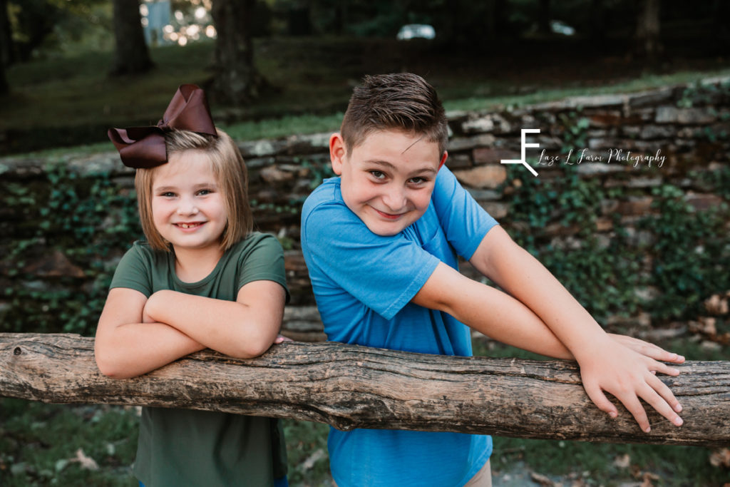 brother and sister in front of stone wall