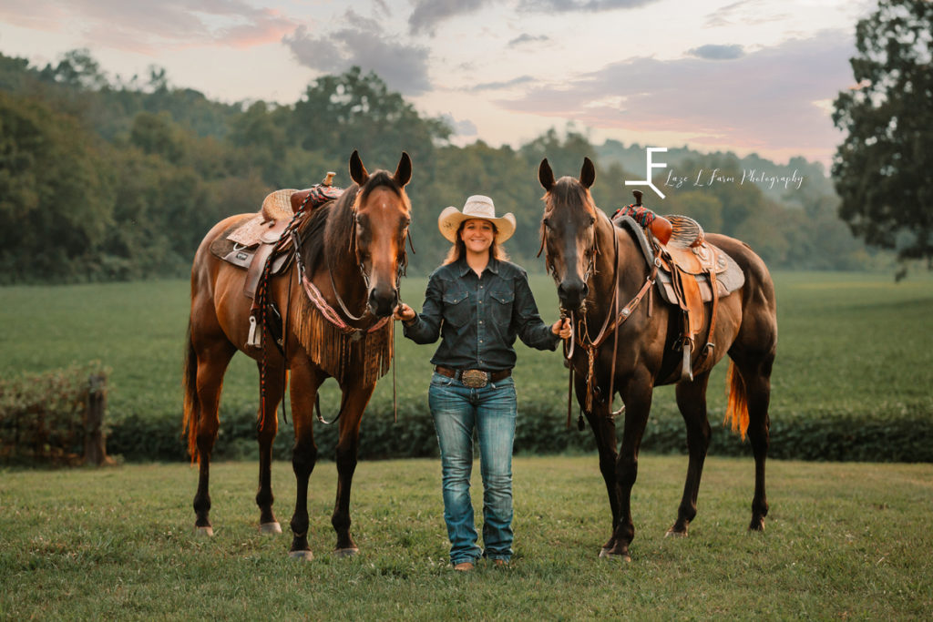 cowgirl with her horses at sunset