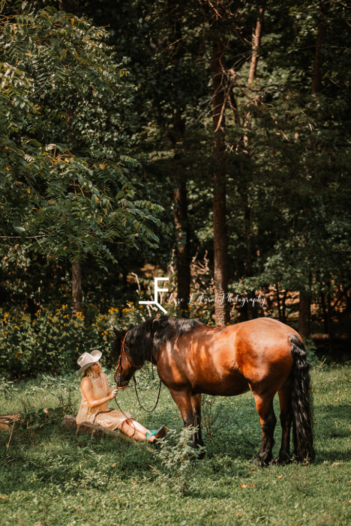 cowgirl sitting with horse in field