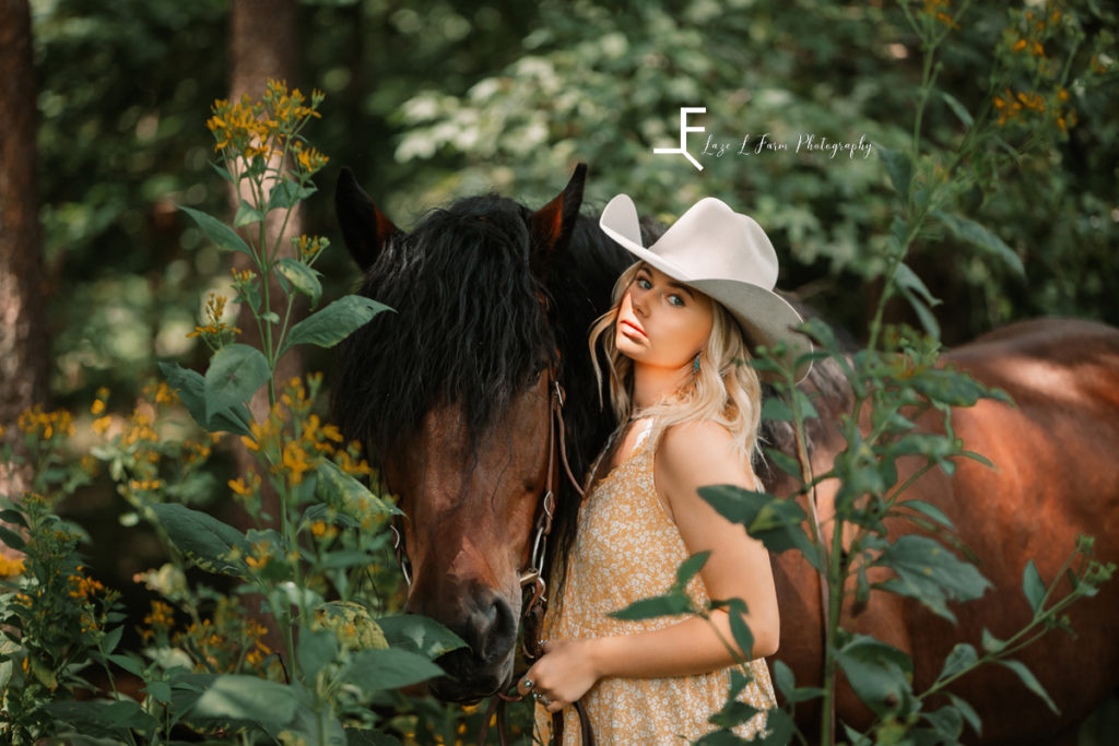 cowgirl with horse with tall yellow flowers