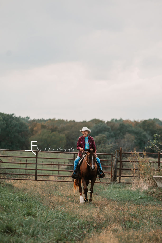 older cowboy riding fence line