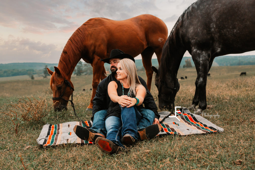 western couple sitting with horses grazing