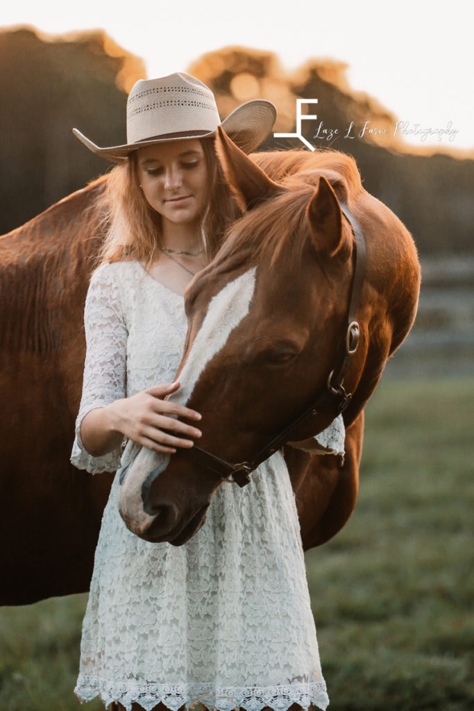 cowgirl in white dress loving horse