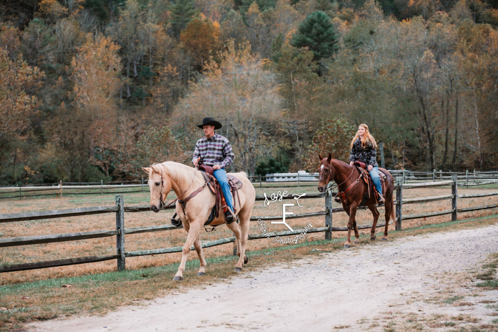 western couple riding down fence line