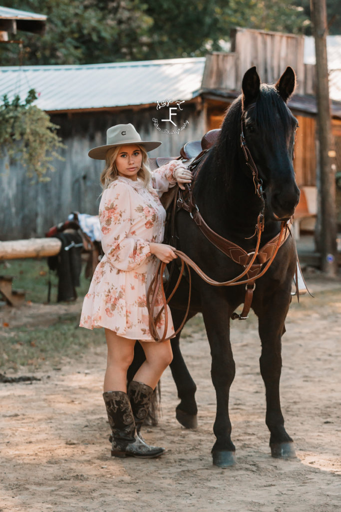 cowgirl in pink dress with black horse