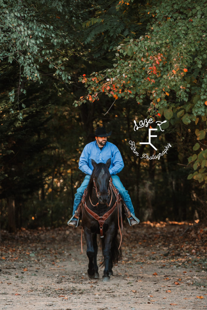 cowboy riding black horse