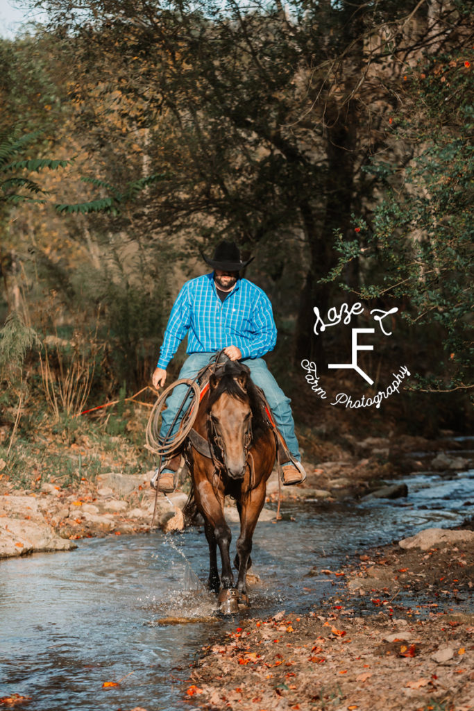 cowboy riding horse through the water