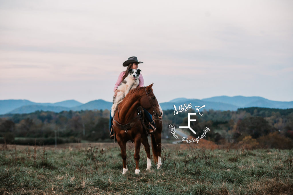 cowgirl holding dog on horseback