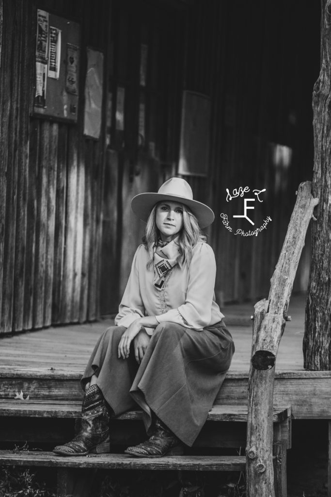 cowgirl sitting on steps in black and white