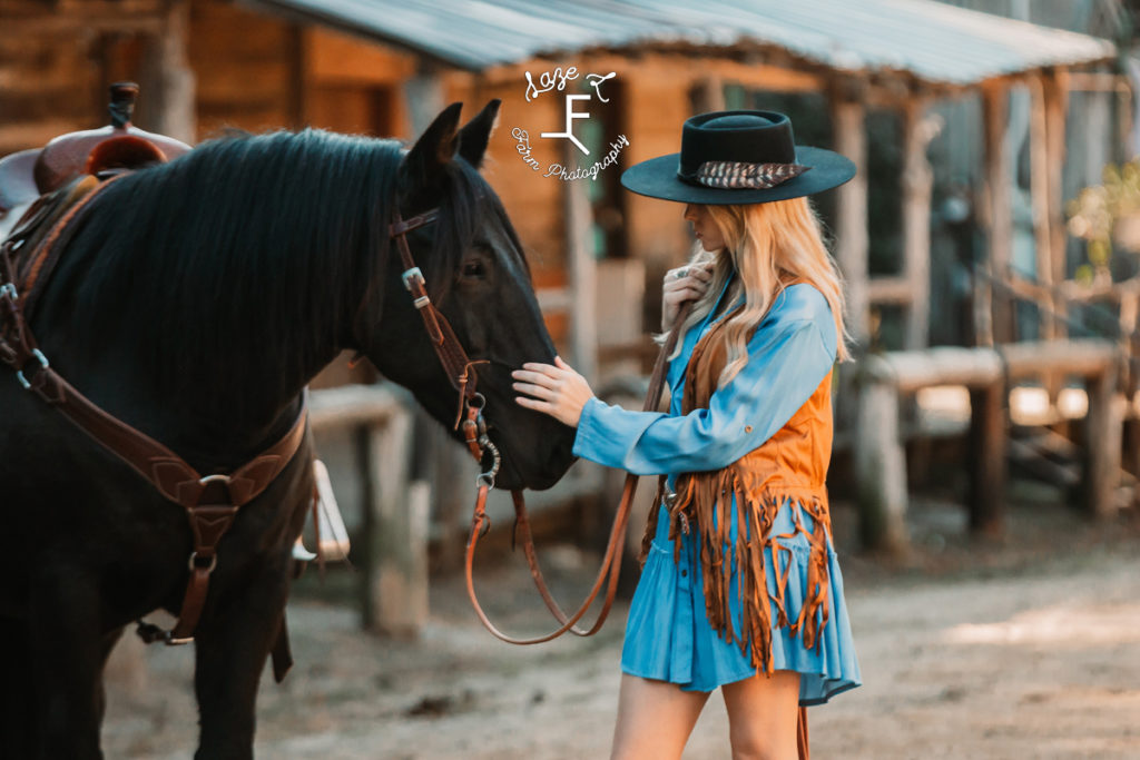 cowgirl in blue dress with black horse