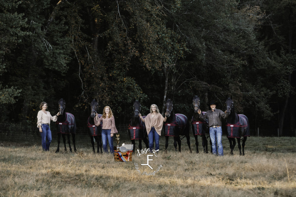 family of 4 with 6 black horses