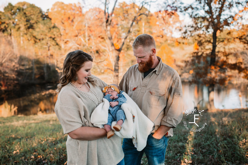 mom and dad looking at baby girl