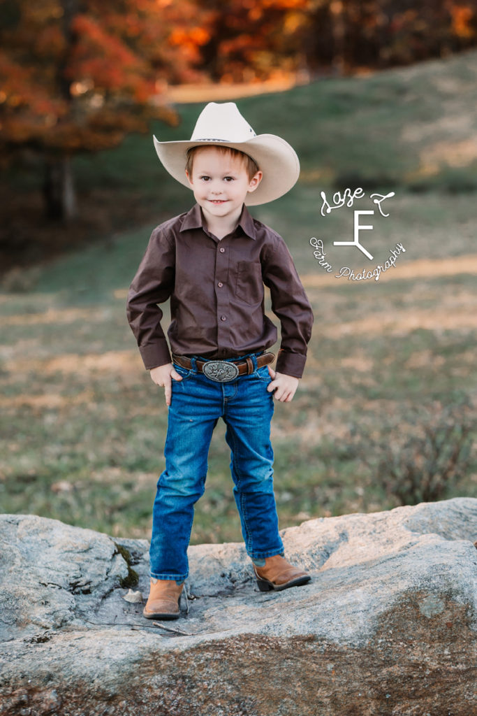 little cowboy standing on rock